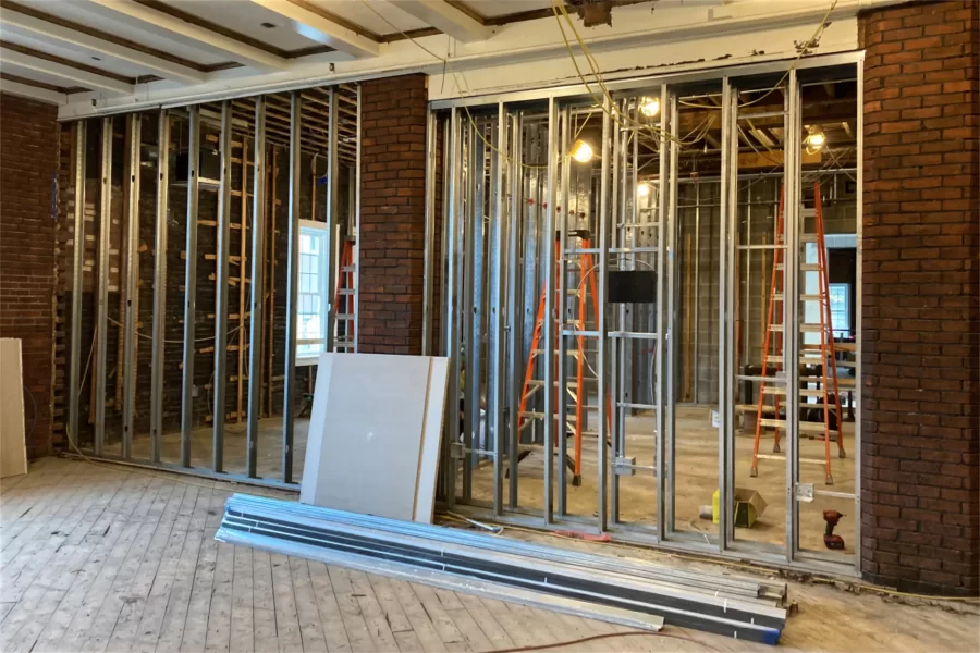 Surprise! Beneath the wallboard, the Chase renovation team expected to find a solid brick wall separating Chase Lounge from the lobby — but what was there instead were two brick columns. (Doug Hubley/Bates College)