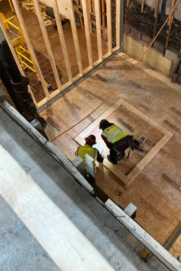 Workers plan the next step in the creation of a new stairway near the entrance facing Carnegie Science. (Doug Hubley/Bates College)