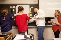 Assistant Professor of Education Mara Tieken circulates among small groups of students as they discuss what makes good teaching. Through fieldwork and classroom work, education students learn about the field’s interdisciplinary perspectives and the practical realities today.