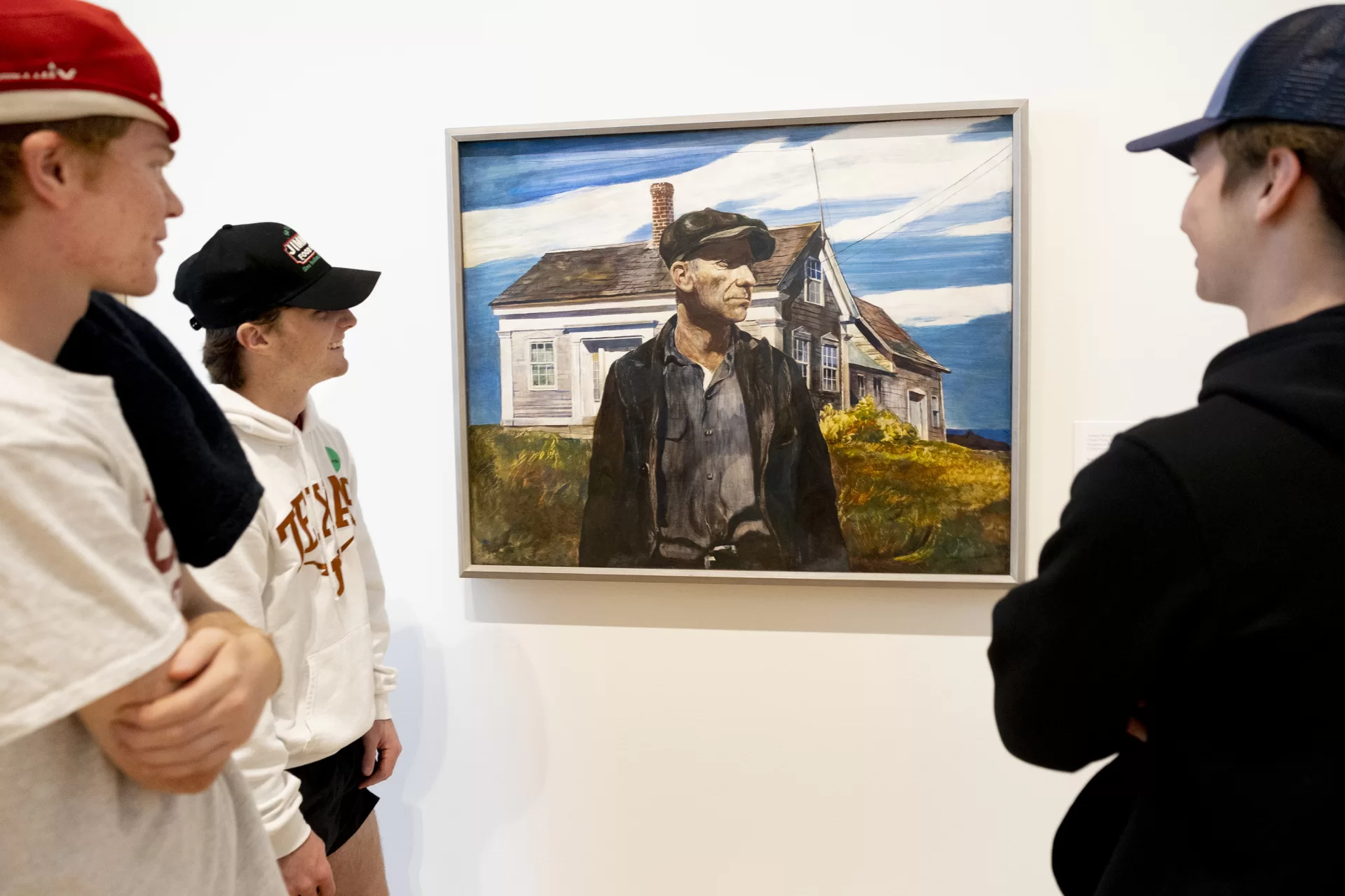 An early work of Andrew Wyeth’s, Charlie Ervine (1937, tempera on panel) captures the attention of Josh Smith of Farmington, Maine, Joe Yoxall ’26 of Dallas, and Liam Shlager of Ross, Calif. (Phyllis Graber Jensen/Bates College)