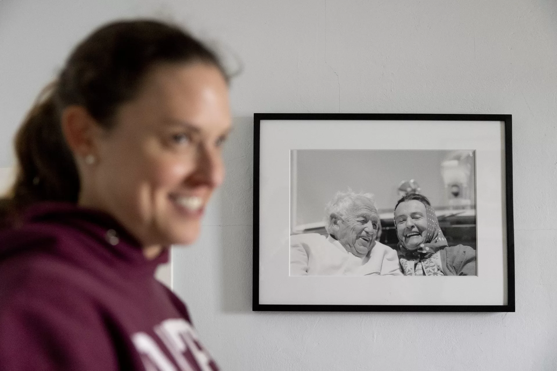 Victoria Wyeth ‘01 smiles at students in front of a photograph she made of  her grandparents, Andrew and Betsy Wyeth that hangs in her Cushing, Maine, home. (Phyllis Graber Jensen/Bates College)