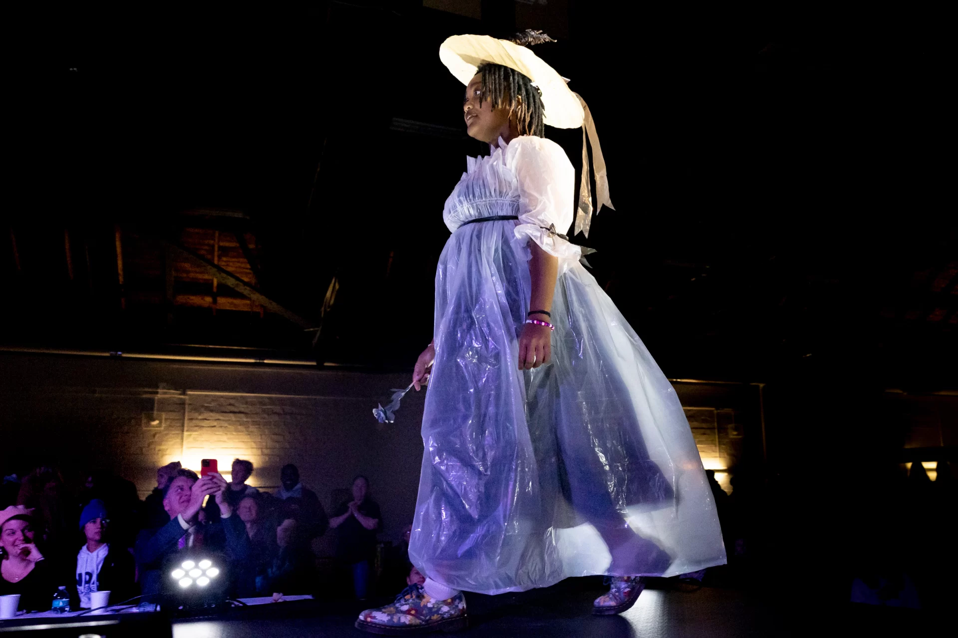 The Trashion Show, including Harvest Meal desserts served by Bates College Dining  in Commons on Nov. 16, 2022, was held in the Christian Daggett Gray Athletic Building.

Contestants:
First Place: Miguel Pacheco '24, wearing stilts and a dress made of recycled book covers, created by Sloan Phillips '25.
Second Place: Bora Lugunda '25, wearing a Marie Antionette-inspired gown made from trash bags and plastic sheeting, and a hat made from cardboard and brown packing paper, created by Grace Acton '24
Third place: Claire Barlass '25, wearing a self-designed "milk dress" made from discarded milk cartons from Commons, an outfit that was also her Halloween costume this year.

Quinn Macauley '24, wearing a "mermaid-inspired" outfit made from trash/discarded swim gear from Tarbell Pool, created by Talia Skaistis '25 and Lianna Rosman '26, all three students are on the Bates Swimming and Diving TeamLily Ritch '25, wearing a "puffy jacket-inspired" outfit made from discarded bubble wrap, chip bags, coupons, mesh orange bag, and straws, created by Emma Righter '23, and accessories by Ella Lungstrum '23 .Leen Dockery '26, wearing a self-created cowgirl-inspired outfit made from discarded cardboard from the Parker 4th floor recycling bin. (I didn't recognize her in the outfit! I remember her from the Visio Divina photos) (edited) 
3:39
Let me know if you want the self-written descriptions for their outfits. I have the script Theo shared, and I can pick them out (there were a lot of withdrawals, I guess! There are like 13 names on the script)

Plus one more male contestant:
7. As Abraham Lincoln once said: there is nothing like a sour patch kid to brighten your day! In this issue of munchies, Henry Welch, Ben Huston, and Jonah Yaffee design a chic, yet delicious outfit of sour patches, chips, goldfish bags, and other assorted snacks to express the intrinsic human primal desire for food, and boy does it look good.