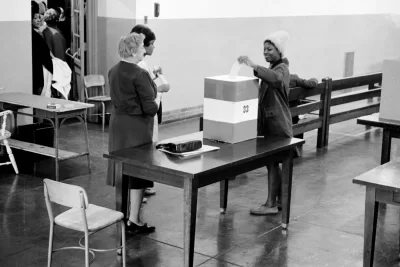 Negro voting in Cardoza [i.e., Cardozo] High School in [Washington,] D.C. / [MST].SummaryPhotograph showing a young African American woman casting her ballot.Trikosko, Marion S, photographer. Negro voting in Cardoza i.e., Cardozo High School in Washington, D.C. / MST. Washington D.C, 1964. Nov. 3. Photograph. https://www.loc.gov/item/2003688167/.