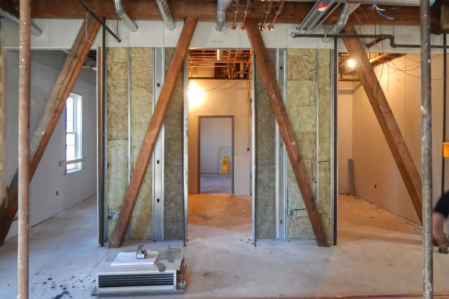 Offices and a meeting room in the first-floor Purposeful Work suite in Chase Hall. The insulation will provide soundproofing. The wooden trusses are original to century-old Chase Hall and will be left exposed. (Doug Hubley/Bates College)