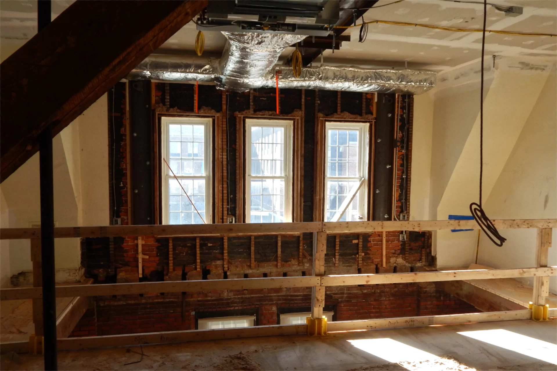 The opening in the floor of this room on Chase Hall’s second story is temporary. The floor was removed because old water damage. After repairs to the brick wall under the windows, the existing flooring will be extended to the wall again. Doug Hubley/Bates College)