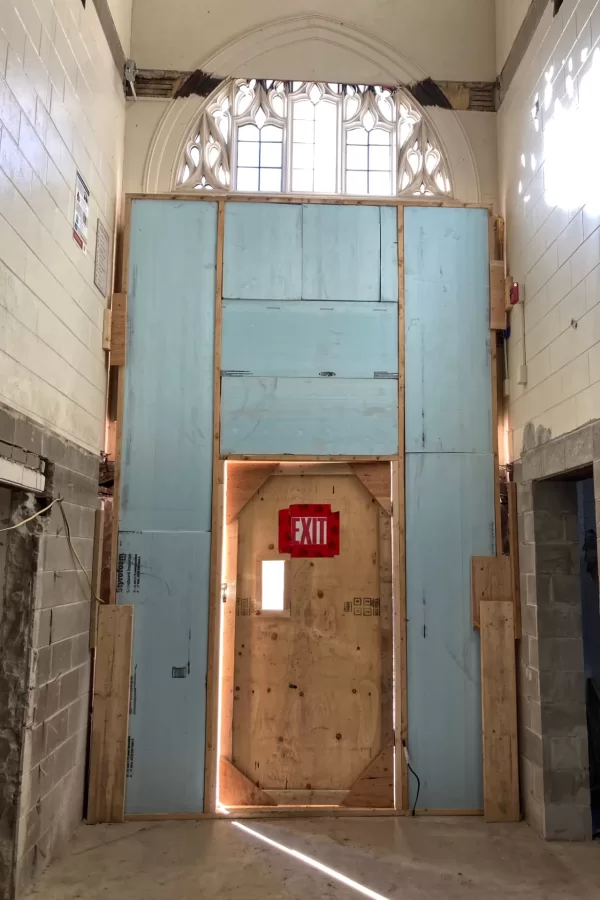 A temporary door in the Chase Hall entrance near the Kenison Gate is surrounded by pale-blue insulation. The doorway at the left opens to the ground-level lobby, and the one at right to the Little Room. (Doug Hubley/Bates College)
