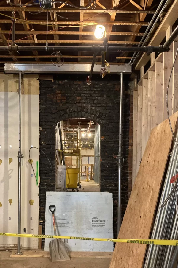 This view toward the central stair from Chase Hall's lobby provides a sense of the building’s multilayered personality. The arched doorway frames a corridor that's a half-level higher than the lobby. (Doug Hubley/Bates College)