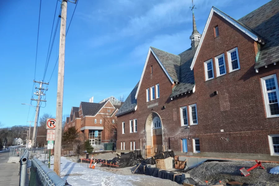 From left, Campus Avenue, the site fence, Carnegie Science Hall, and a Chase Hall entrance fronted by new hardscaping, swaddled against the weather. The Kenison Gate is barely discernable behind the signpost and adjacent utility pole  at left. (Doug Hubley/Bates College)