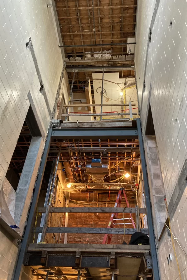 And here's a look upward inside that same Chase entrance near the Kenison Gate. Shown are two of the three levels of the original Chase Hall. The top opening leads to the lobby for Skelton and Hirasawa lounges. One level down is the Purposeful Work suite. At bottom outside the image frame, the main building entrance will be reconfigured. The new gray steel framework by the doorways will support floor extensions into this former stairwell. (Doug Hubley/Bates College)