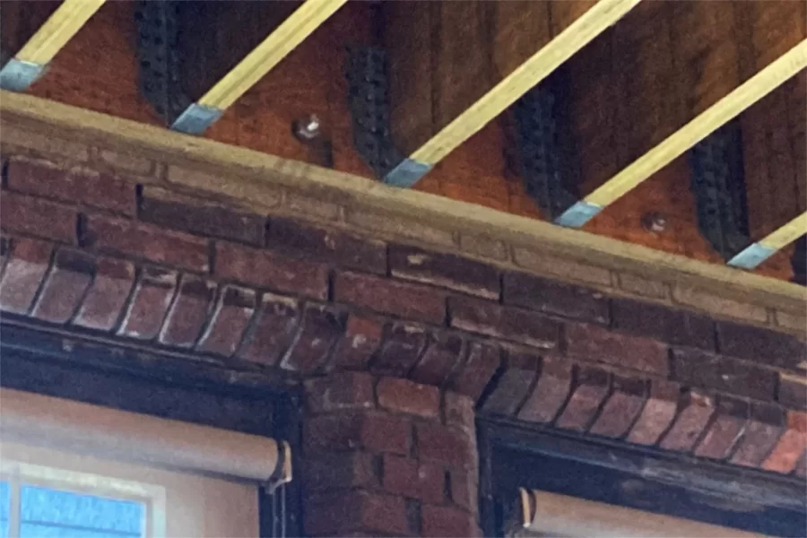 Here's a close view of the new joists, ledger board, and rebuilt masonry used to replace a patch of water-damaged floor decking above Chase Hall Lounge. (Doug Hubley/Bates College)