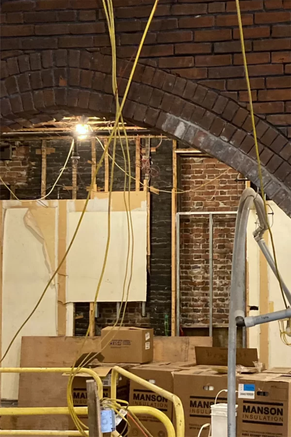 Although there has always been a doorway in this opening at the far end of Chase Lounge, the brick arch was concealed behind wallboard for decades. Like several other architectural treats original to Chase Hall, the arch will be left exposed by the current renovation. Note the pale new brick. (Doug Hubley/Bates College)