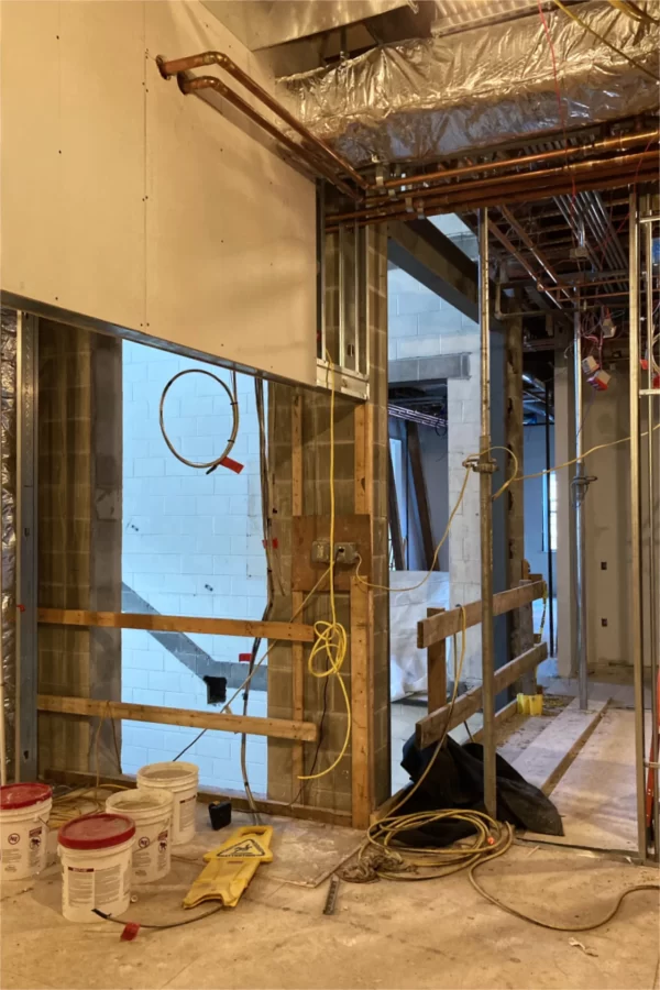 Wooden guardrails mark where, in the Purposeful Work suite, the first floor will extend into the Campus Avenue entrance that will serve as a kind of atrium, with a similar arrangement on the second floor. Glass walls will admit daylight. (Doug Hubley/Bates College)