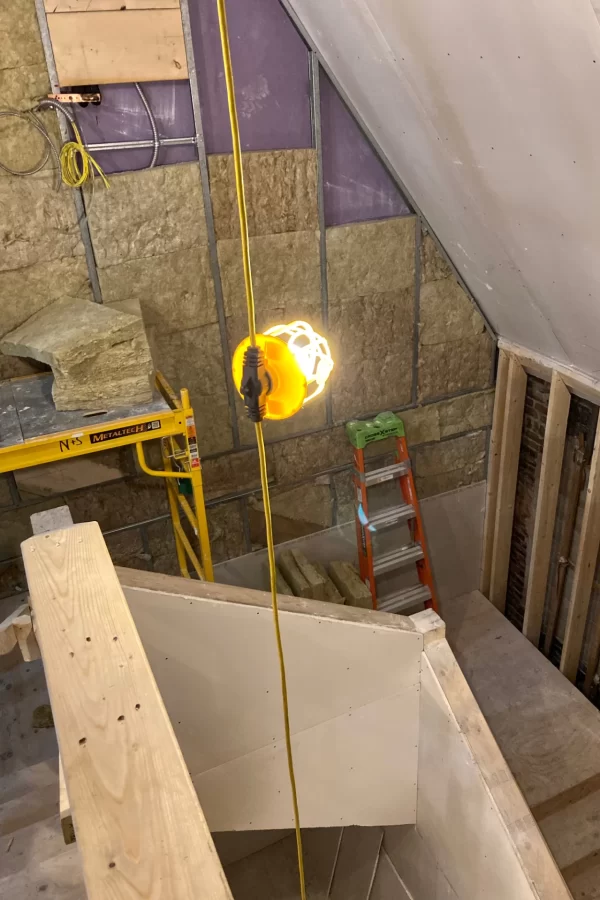 This new stairway connecting Chase Hall’s first-floor lobby with the second story is being Insulated. The Rockwool insulation provides both fire protection and acoustic damping. (Doug Hubley/Bates College)