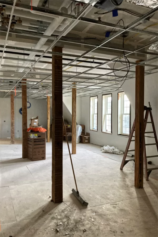 Utility rough-ins are about done, the first coat of finish paint applied, and the ceiling grid hung in this open area on the second floor of Chase Hall. (Doug Hubley/Bates College)