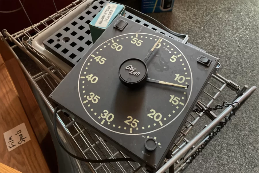 Remnants of the Chase Hall darkroom, used in ancient times for producing images from paper, strips of celluloid, and precious metals, are stored in the once and future office of the Bates Student newspaper. Shown is the darkroom timer, used for controling chemical reactions. (Doug Hubley/Bates College)