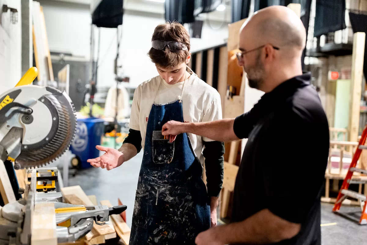 Justin Moriarty, technical Director for Theater and Dance, directs students Natalia Jacobs '26 of Amherst, Mass., (in downstairs shop) and Gideon Berrie '26  of New York City (on the Schaeffer Theatre stage)  in building and painting sets in the shop and on the stage of Schaeffer Theater with the assistance of Aidan McDowell on February 14, 2023.