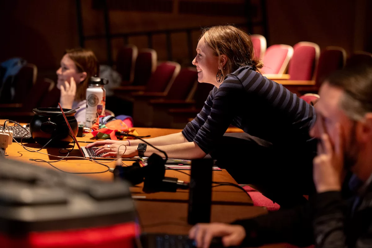 Mia Bernstein ’23 of Bedford, Mass., teaches a dance to actors in Shakespeare’s “Much Ado About Nothing” directed by Assistant Professor of Theater Tim Dugan on the stage of Schaeffer Theatre on Feb. 16, 2023. Stage Manager Lucie Green ’23 of Pittsburgh is also shown in action, seated and moving throughout the theater seats.