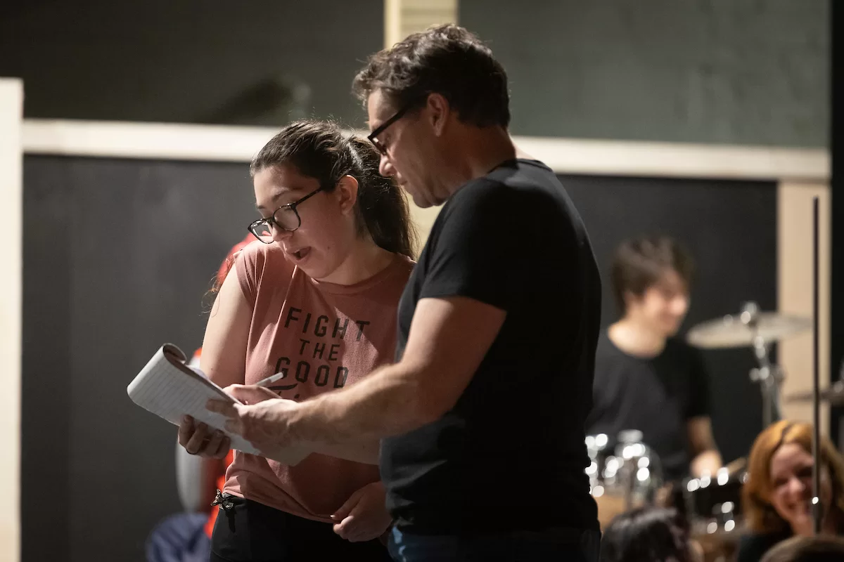 Mia Bernstein ’23 of Bedford, Mass., teaches a dance to actors in Shakespeare’s “Much Ado About Nothing” directed by Assistant Professor of Theater Tim Dugan on the stage of Schaeffer Theatre on Feb. 16, 2023. Stage Manager Lucie Green ’23 of Pittsburgh is also shown in action, seated and moving throughout the theater seats.