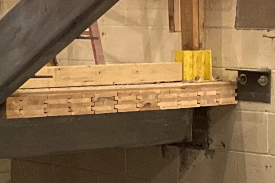 Here’s a view of Lock-Deck tongue-and-groove, cross-laminated timber floor in the central stair. Note the contrasting colors of the crossed wood layers, or lamellas. The gray metal angle at right will support a stair tread. (Doug Hubley/Bates College)