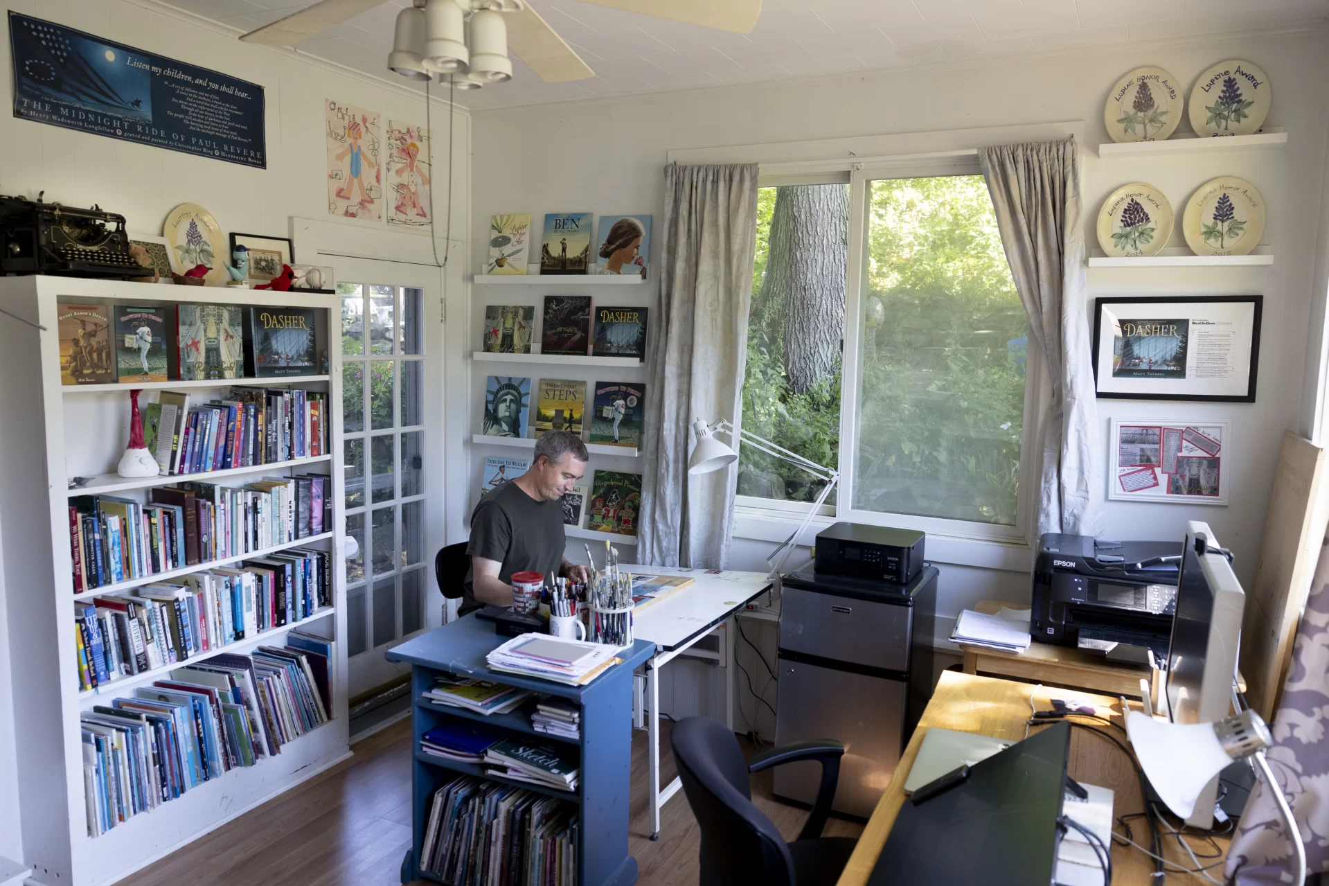 Children’s book illustrator author Matt Tavares ’99 in his Ogunquit, Maine, home and studio as he is interviewed by writer Mary Pols.
Published by Candlewick Press, his first graphic novel, “Hoops” is due out in March, 2023.
Tavares lives in Ogunquit, Maine, grew up in Winchester, Mass., and majored in studio art at Bates. His senior thesis project, a children’s picture book about baseball, later became Tavares’ first book, Zachary’s Ball. Published in 2000 by Candlewick Press, it won the Massachusetts Book Award in 2000 and launched Tavares’ career as an author and illustrator.