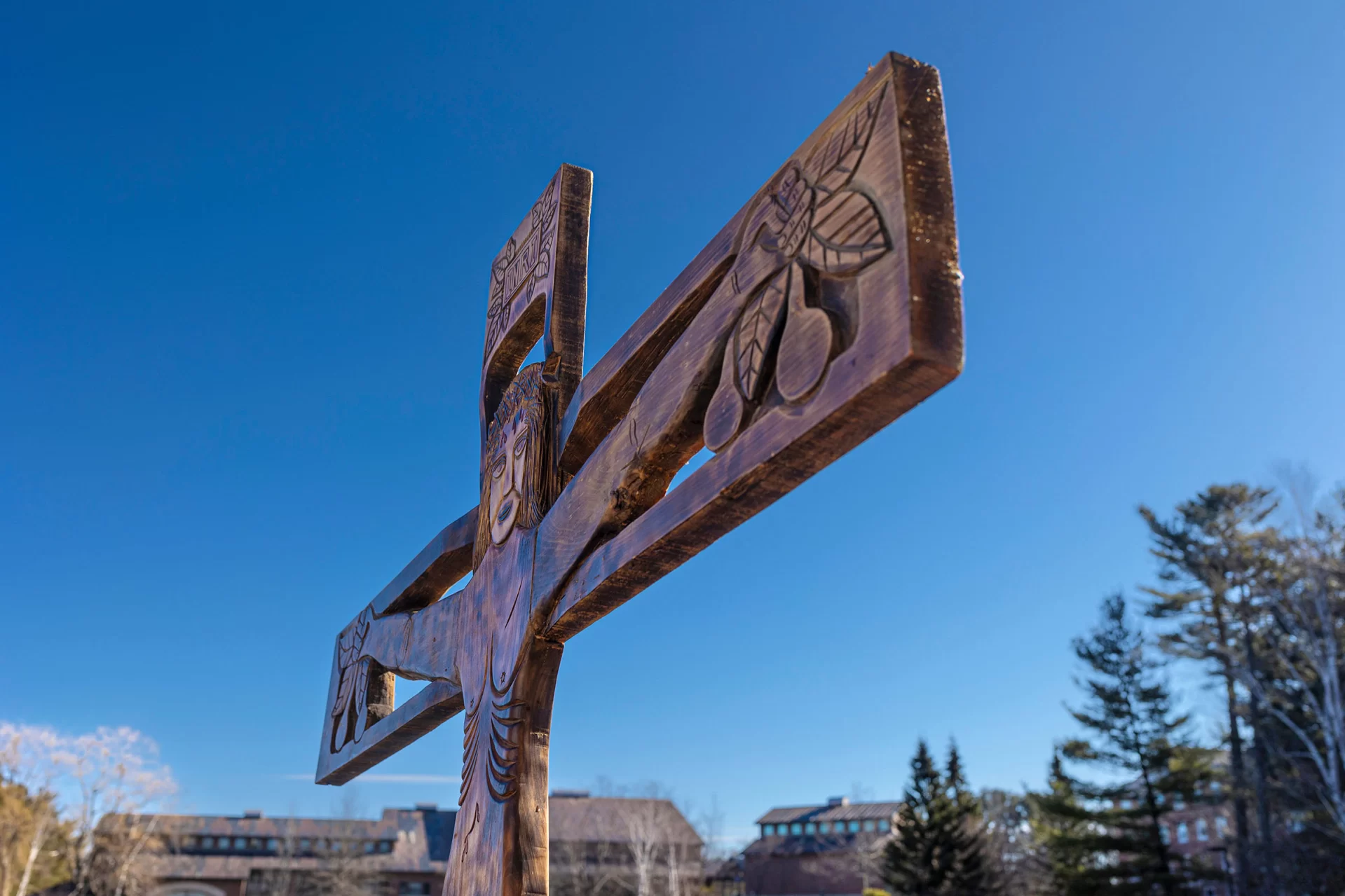 What: Wood sculpture of Christ on the cross
Created by: The Brazilian sculptor Ziltamir Sebastião Soares de Maria (1947–2013) (aka "Manxa") was in residence at Bates in spring 1971 under a program called "Maine's Partners of the Alliance," a culture exchange program then part of USAID and now a private entity called "Partners of the Americas."
Name: The back of the sculpture, which is, has what appears to be its Portuguese title, Auto Retrato Do Meu Povo, (“OWtoh hrayTRAtoh doh MEI-oh POvoh”, roll the “r”s in retrato) or "Self Portrait of My People"
Size: 7 feet tall and 5 feet 8 inches wide
When Created: The back has written March 5, 1971, with a dollar figure (a price estimate for a potential sale?) also written ($800).
Inscription at Top: “INRI,” Latin for “Jesus, King of the Jews,” commonly seen on crucifixes.
Fruit: The fruit that Jesus grasps could reflect Manxa’s style of indiginous Brazilian art. He “carved in wood... sometimes with spaces in copper inlays, characters, crafts and all tropical flora of Rio Grande do Norte,” his home state in Brazil.