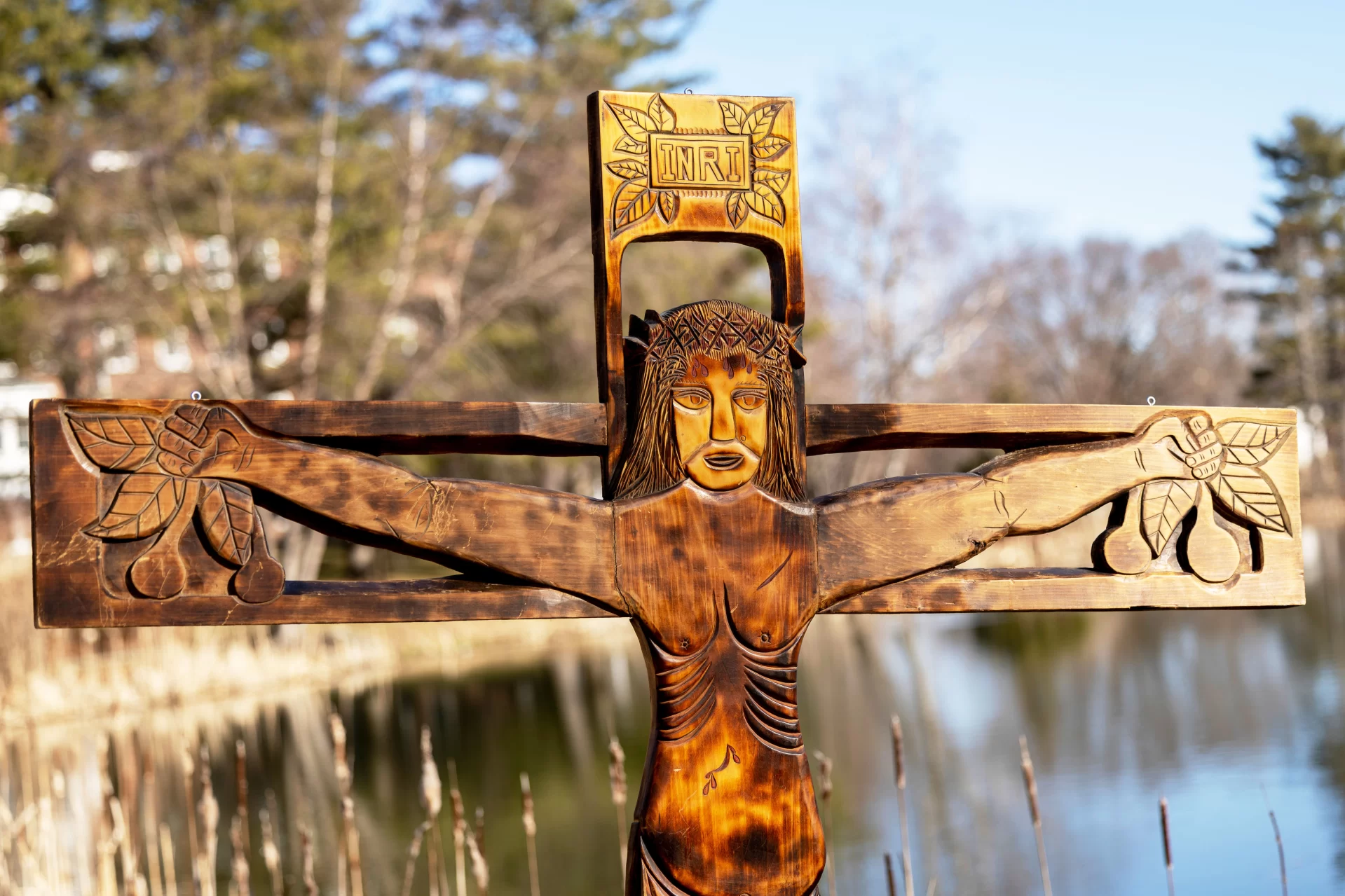 What: Wood sculpture of Christ on the cross
Created by: The Brazilian sculptor Ziltamir Sebastião Soares de Maria (1947–2013) (aka "Manxa") was in residence at Bates in spring 1971 under a program called "Maine's Partners of the Alliance," a culture exchange program then part of USAID and now a private entity called "Partners of the Americas."
Name: The back of the sculpture, which is, has what appears to be its Portuguese title, Auto Retrato Do Meu Povo, (“OWtoh hrayTRAtoh doh MEI-oh POvoh”, roll the “r”s in retrato) or "Self Portrait of My People"
Size: 7 feet tall and 5 feet 8 inches wide
When Created: The back has written March 5, 1971, with a dollar figure (a price estimate for a potential sale?) also written ($800).
Inscription at Top: “INRI,” Latin for “Jesus, King of the Jews,” commonly seen on crucifixes.
Fruit: The fruit that Jesus grasps could reflect Manxa’s style of indiginous Brazilian art. He “carved in wood... sometimes with spaces in copper inlays, characters, crafts and all tropical flora of Rio Grande do Norte,” his home state in Brazil.