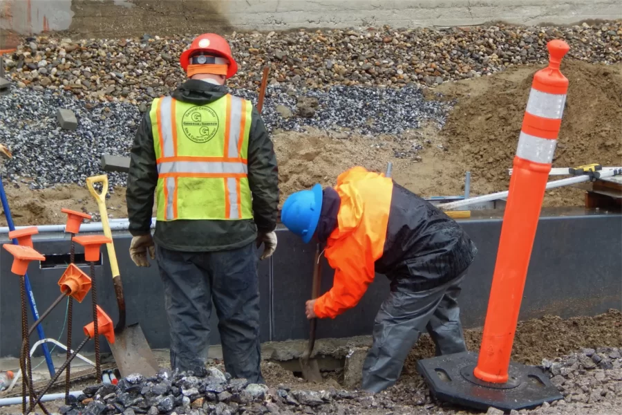 Workers for Gendron & Gendron locate the edge of a wall footing in front of Chase Hall. (Doug Hubley/Bates College)