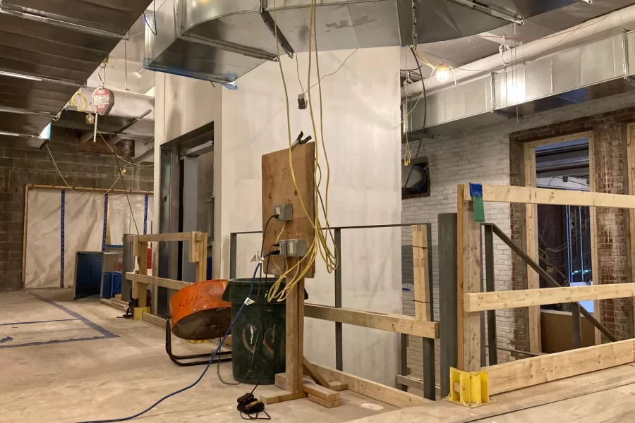 The central stair as seen from a main corridor connecting to Chase Hall’s first-floor lobby. The walkway at right is temporary, placed over a flight of steps to provide a platform for wallboard hangers and painters. (Doug Hubley/Bates College)