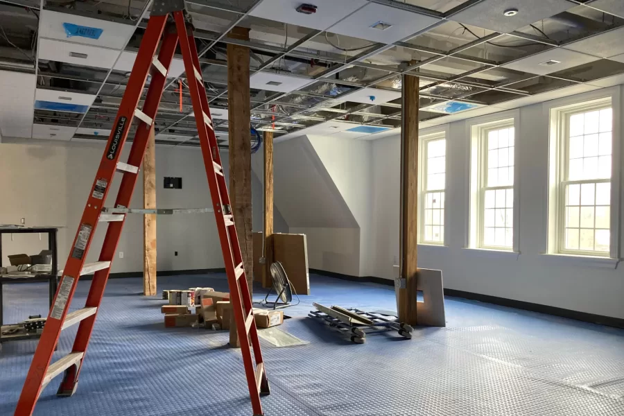 A study lounge on Chase Hall’s second floor. The wooden columns, which are load-bearing, will keep their natural appearance. The blue material protects new carpeting from premature wear. (Doug Hubley/Bates College)