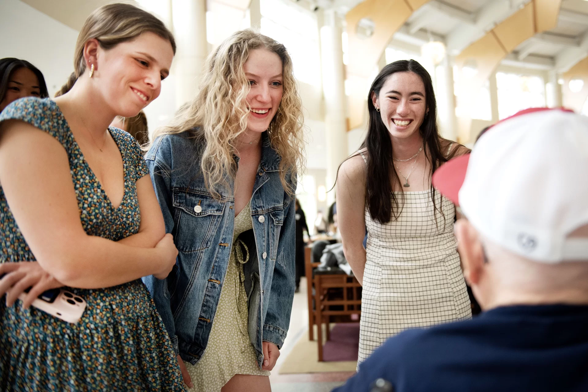 Members of the Bates rowing team Lucy Del Col ’24 of Wellesley, Mass.; Oli Seline ’24 of Delaware, Ohio and Hannah Braslau ’23 of Chelmsford, Mass. talk with Ralph Sylvester ’50 during the dedication of the new rowing shell at Perry Atrium in Pettengill Hall on April 29, 2023.