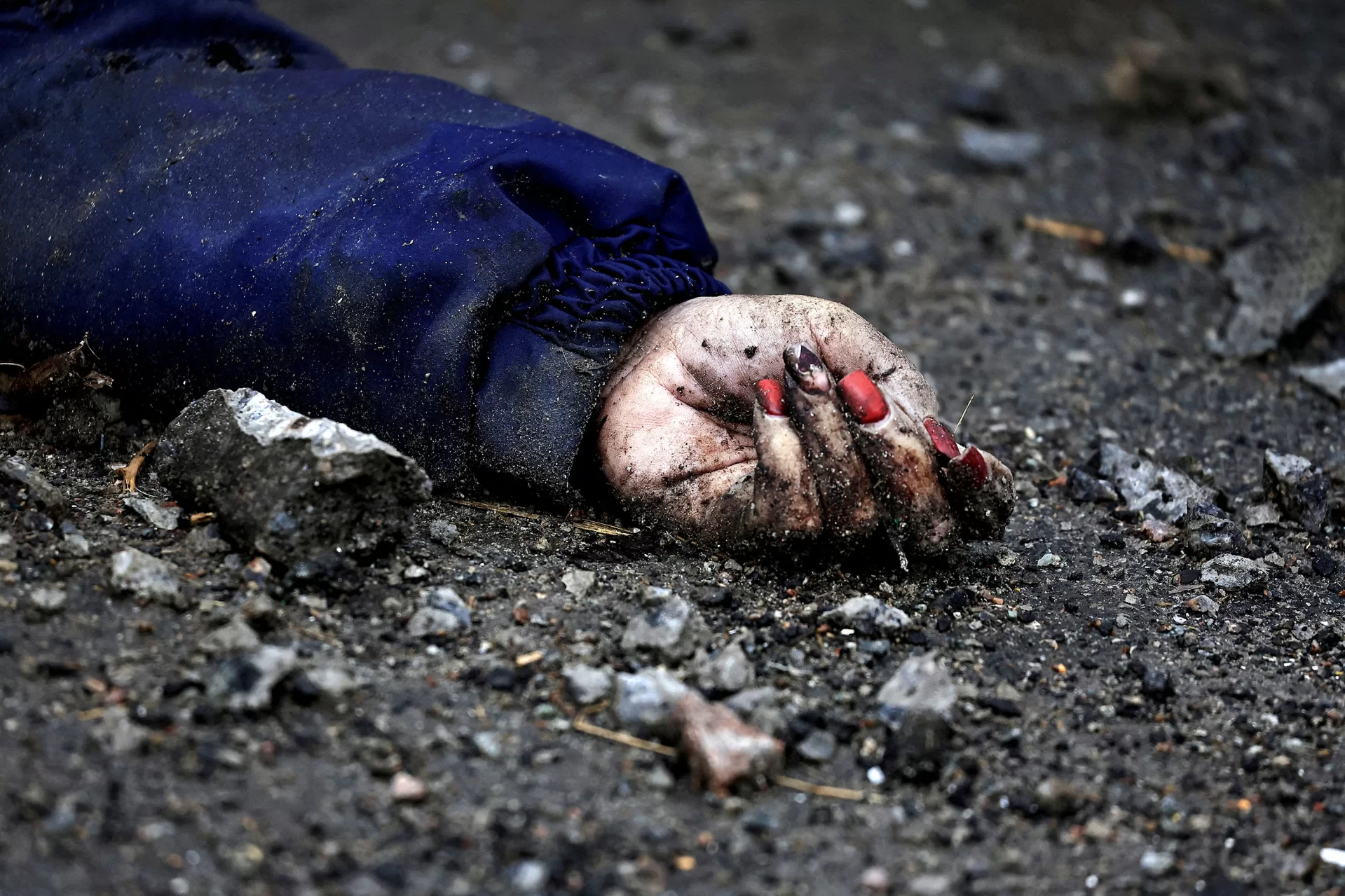 FILE PHOTO: SENSITIVE MATERIAL. THIS IMAGE MAY OFFEND OR DISTURB        The hand of Iryna Filkina, a woman who according to residents was killed by Russian army soldiers, is pictured as her body lies on the street, amid Russia's invasion of Ukraine, in Bucha, Kyiv region, Ukraine April 2, 2022.        REUTERS/Zohra Bensemra SEARCH " UKRAINE-CRISIS/ANNIVERSARY-TIMELINE" FOR ALL IMAGES/File Photo