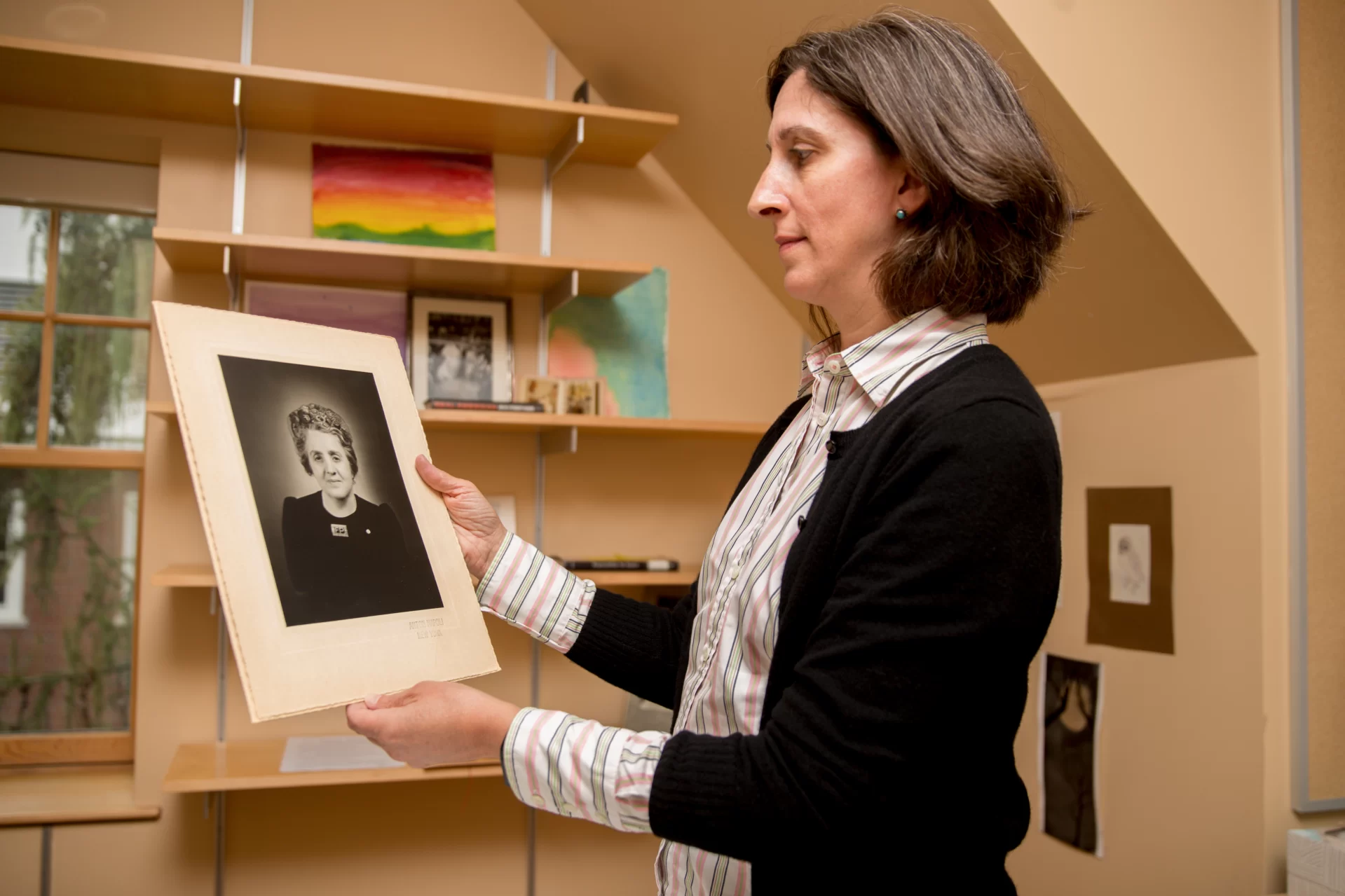 Associate Professor of Philosophy Susan Stark in her Hedge Hall office where she proudly displays a photographic portrait of her great-grandmother Flora who did not go to her job at the March 25,1911, Triangle Shirtwaist Factory on the day a fire raged out of control and killed 146 workers.