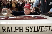 Ralph Sylvester ’50 christens the new rowing shell at Perry Atrium in Pettengill Hall on April 29, 2023. Bates Rowing Head Coach Peter Steenstra presented Sylvester with a blade during the dedication ceremony making Sylvester the only non-rower to receive one.