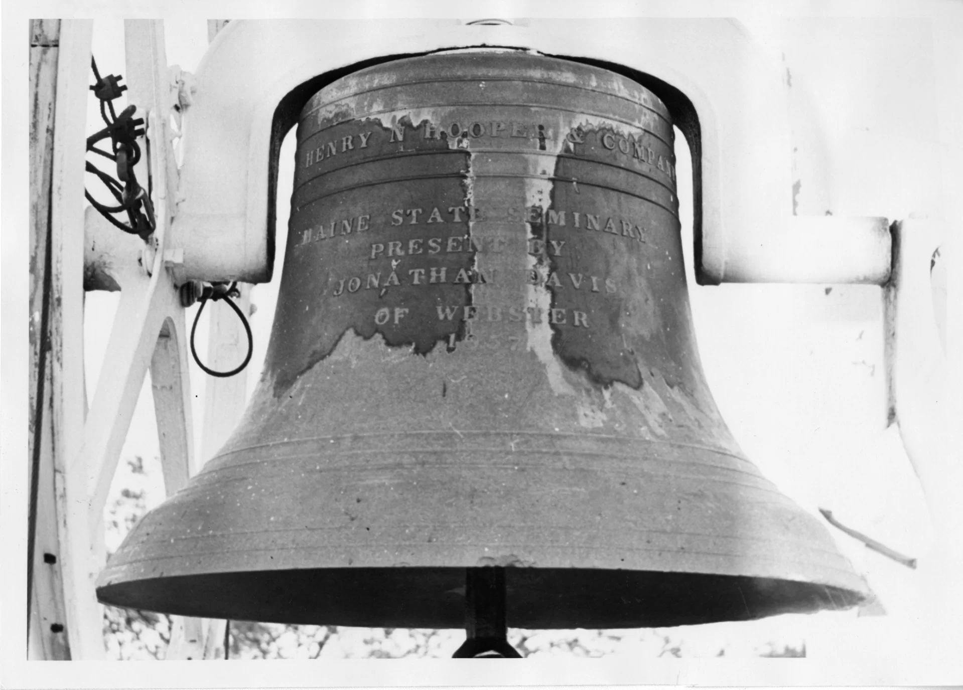 The Hathorn Hall bell, shown in an undated photo. At left, note the cable on the wheel that’s attached to the bell. Originally, hand-pulled ropes caused the bell to ring. Several decades ago, the present cable and winch system replaced the ropes and  human ringers. (Edmund S. Muskie Archives and Special Collections Library