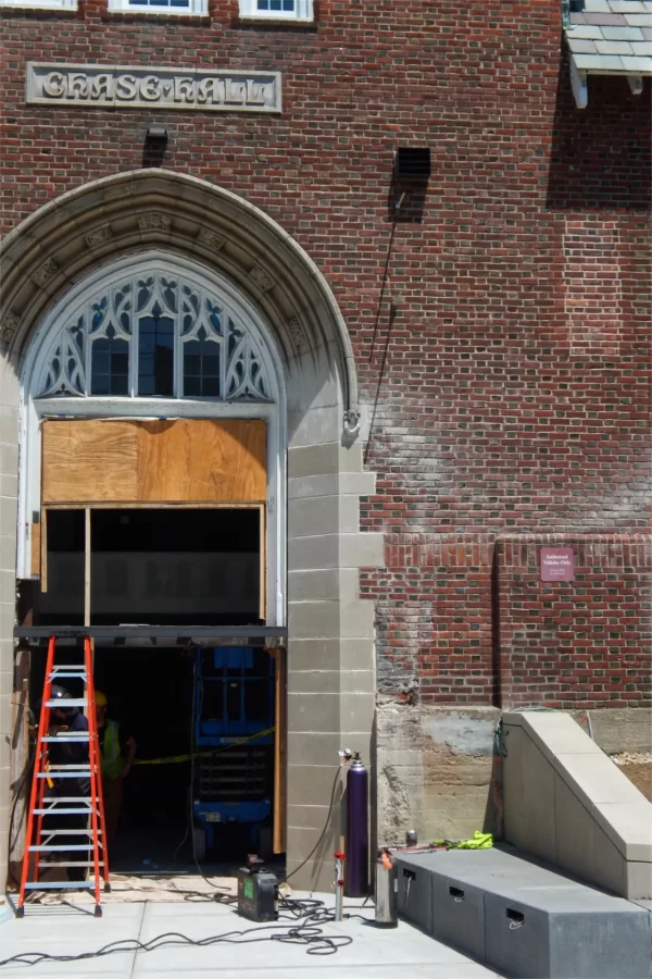 Chase Hall’s primary Campus Avenue entrance, now situated slightly below street level, has bench seating on the outside and will be brilliant with natural light on the inside. (Doug Hubley/Bates College)