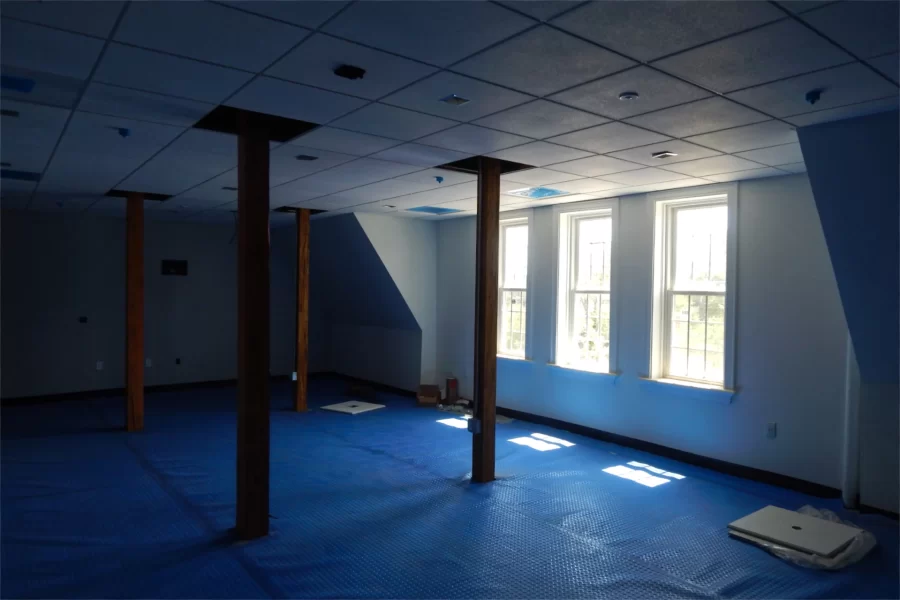 A student lounge on Chase Hall’s second floor, where a yearlong Chase renovation is furthest advanced. The blue material on the floor protects brand-new carpeting from incidental damage. (Doug Hubley/Bates College)