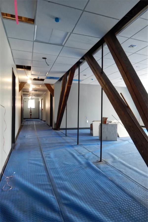 A corridor through Chase Hall’s second floor. The wooden trusses are original to this century-old section of Chase. (Doug Hubley/Bates College)