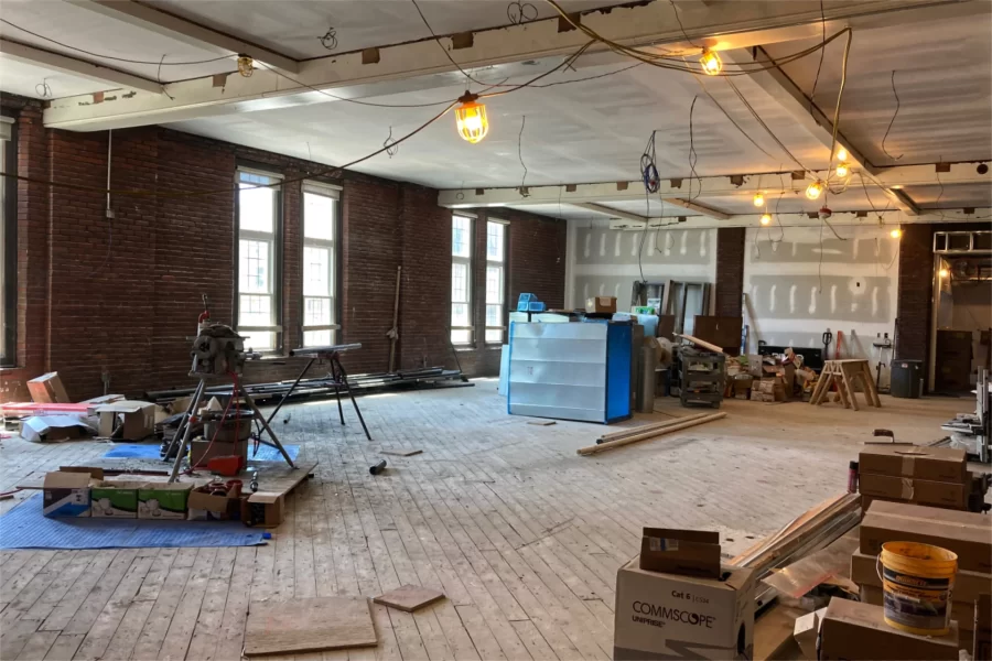 And here’s Chase Hall Lounge in May 2023. Near the end of the current renovation, additional “faux” beams, as well as paint, will be applied to the ceiling and a hardwood floor will be placed. (Doug Hubley/Bates College)