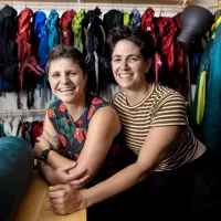 In the basement of Portland’s Equality Community Center, Portland’s newest gear library lacks the store-front appeal of the many outdoor retail shops in a state famous for its outdoor recreation. But one step inside Kindling Collective during its open house on June 10 and the orange and pink walls, the sound of laughter, and the mini outdoor-gear lessons breaking out spoke of a warm, welcoming community and, most of all: joy. Kindling Collective, a gear library focused on the queer community, was founded this spring by business partners, spouses and outdoor enthusiasts Hallie Herz ‘11 (wearing striped shirt) and Eva Fury in an effort to help the LGBTQ+ community access the outdoors in a safe, fulfilling and affordable way. The tiny 400-square-foot space welcome everyone, though it's focused on helping queer people specifically feel welcome, empowered and inspired. Focusing on joy, Hertz said, is central to their mission. Hertz and Fury were photographed at 15 Casco St. on June 15, 2023.