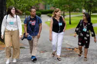 The nearly 200 educators from across the country who gathered this week at Bates College for the Gordon Research Conference came to share new research on ways to make biology education more inclusive, diverse, and accessible in a setting aimed at fostering intense and intimate collaboration. From left, Gordon Research Conferences participants and biologists Madison (“Maddy”) Meuler of Allen Institute (current)/University of Washington (former), Omar Quintero of the University of Richmond, April Hill of Bates College, and Samiksha Raut of the University of Alabama at Birmingham head to lunch in Commons after a morning session in the Olin Arts Center. Hill is Bates’ Wagener family professor of equity and inclusion in STEM