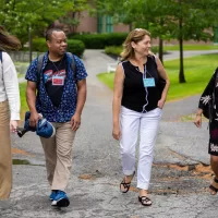 The nearly 200 educators from across the country who gathered this week at Bates College for the Gordon Research Conference came to share new research on ways to make biology education more inclusive, diverse, and accessible in a setting aimed at fostering intense and intimate collaboration. From left, Gordon Research Conferences participants and biologists Madison (“Maddy”) Meuler of Allen Institute (current)/University of Washington (former), Omar Quintero of the University of Richmond, April Hill of Bates College, and Samiksha Raut of the University of Alabama at Birmingham head to lunch in Commons after a morning session in the Olin Arts Center. Hill is Bates’ Wagener family professor of equity and inclusion in STEM