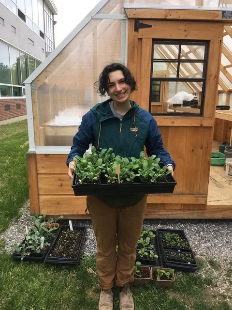 Ellie Vance '21, standing outside a greenhouse at Montello Elementary School in Lewiston. Photo courtesy of Ellie Vance