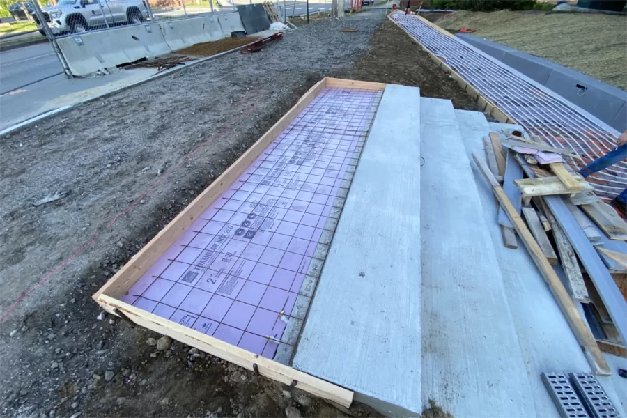 This May 23 photo shows steps under construction near a Campus Avenue entrance to Chase Hall. The pink stuff is insulation and the wire mesh will insulate the concrete that’s about to be placed here. Flexible pipes, like the ones at right, will soon be embedded in the concrete to carry antifreeze as part of a snowmelt system. (Paul Farnsworth/Bates College)