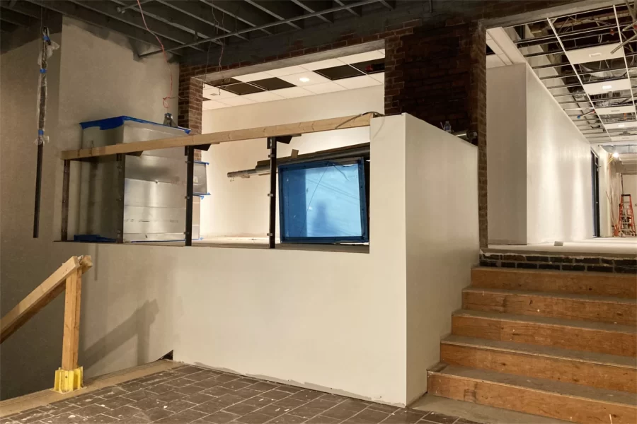 The "Overnook,” a distinctive seating area in Chase Hall’s first-floor lobby, looks spiffy with new wallboard and paint on June 27. Sections of air duct are currently stashed there. (Doug Hubley/Bates College)