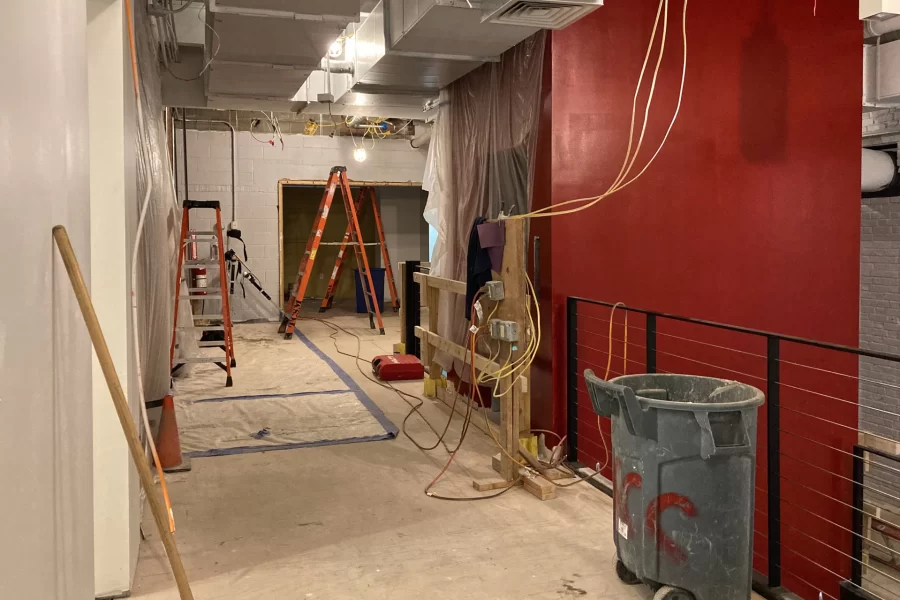 Here’s a view of the central stair approached from Chase Hall’s first-floor lobby. The red walls enclose the elevator shaft. The two ladders stand  at the entrance to the Office of Intercultural Education. (Doug Hubley/Bates College)