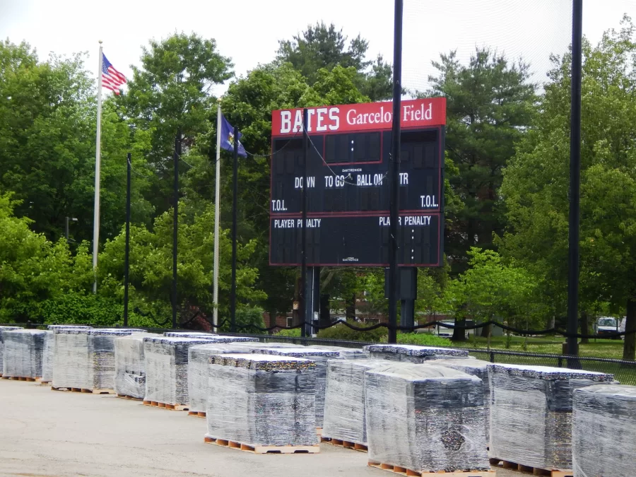 Stockpiled near the Garcelon Field scoreboard on June 27 are shock pads that will underlay the field’s ew playing surface. (Doug Hubley/Bates College)