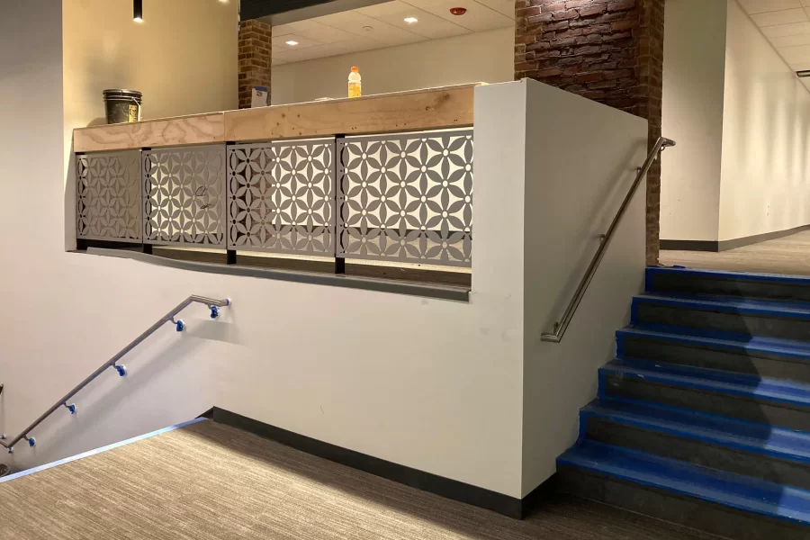 Inspired by Bates Manufacturing Company bedspreads, woven in Lewiston, decorative metalwork has been applied to the front of the Overnook in Chase Hall’s first-floor lobby. (Doug Hubley/Bates College)