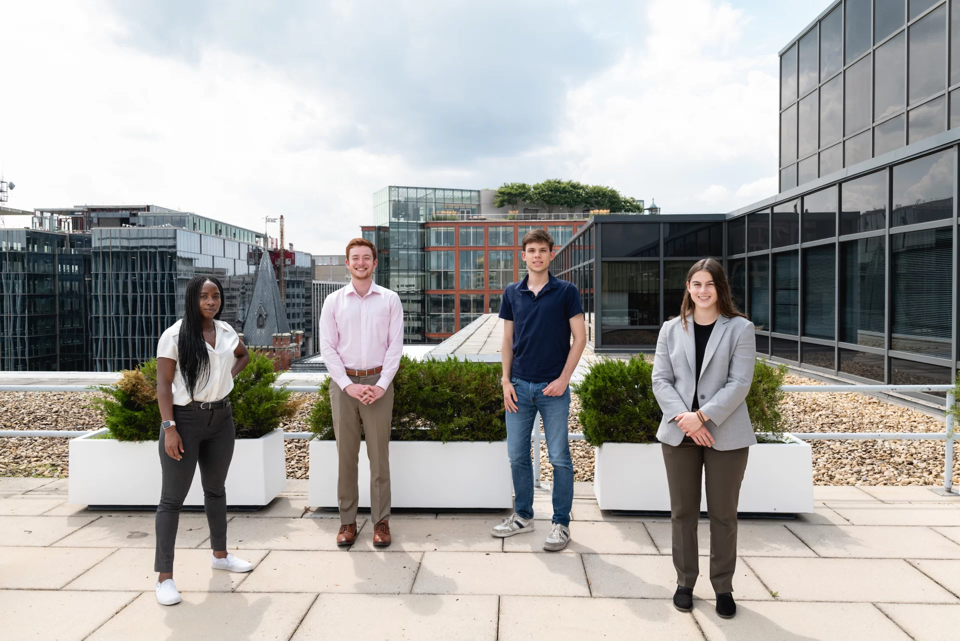 Bates College, class of '24 students: Aaliyah Moore, Jack Lawrence, Perry Beckett, and Emma Rippey, pose for a portrait on the rooftop at their summer internship, at Kellogg Hansen law firm in Washington, D.C., pose for a portrait, on Wednesday, July 19, 2023. Photo by Cheriss May, Ndemay Media Group for Bates College.
