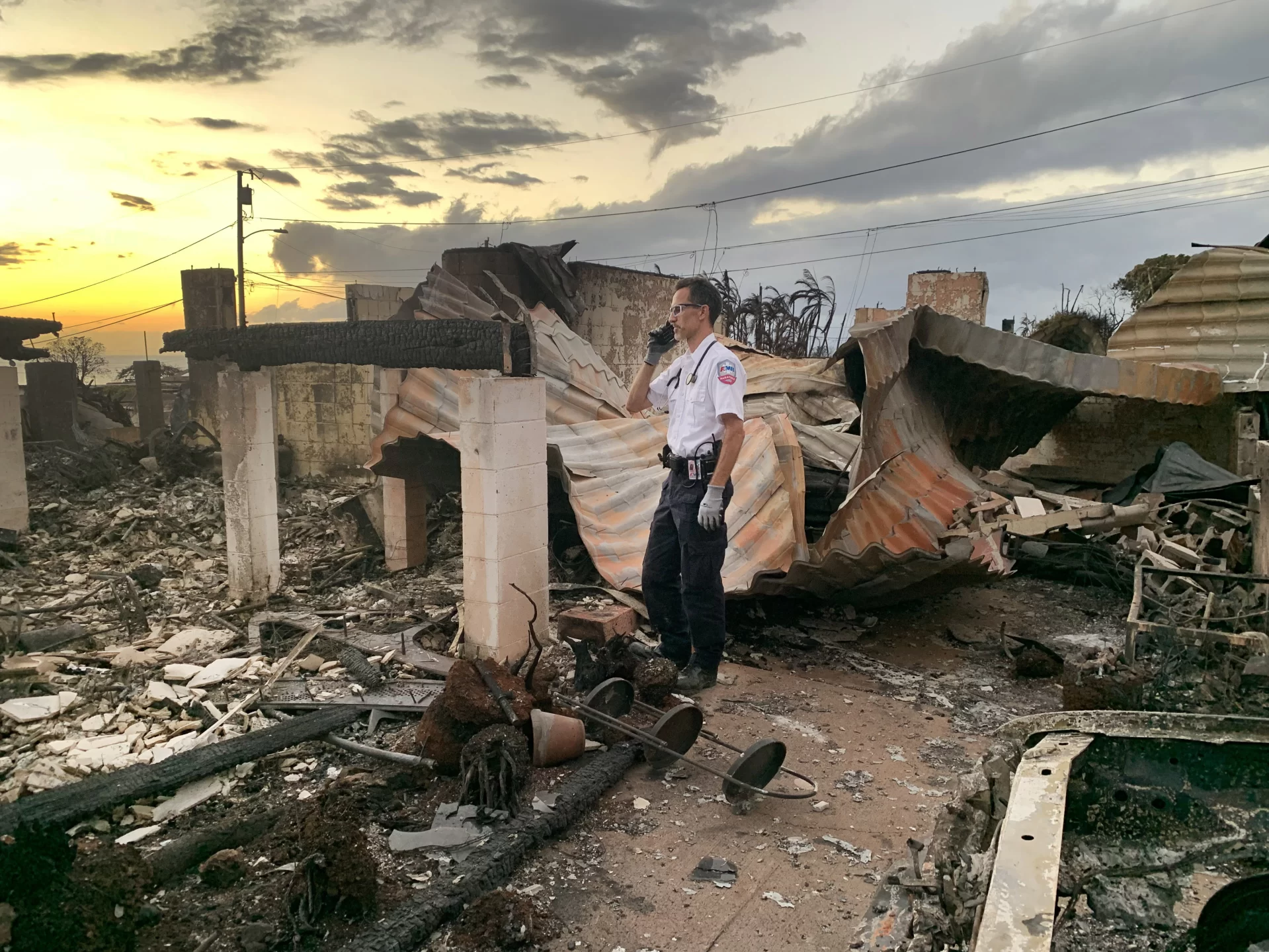 Standing amid the destruction cause by fire on Aug. 10, 2023, David Kingdon ’98 worked on a solo paramedic Special Response Unit in Ma’alaea, Maui,  on the front line helping to treat and transport burn victims during the fires. 