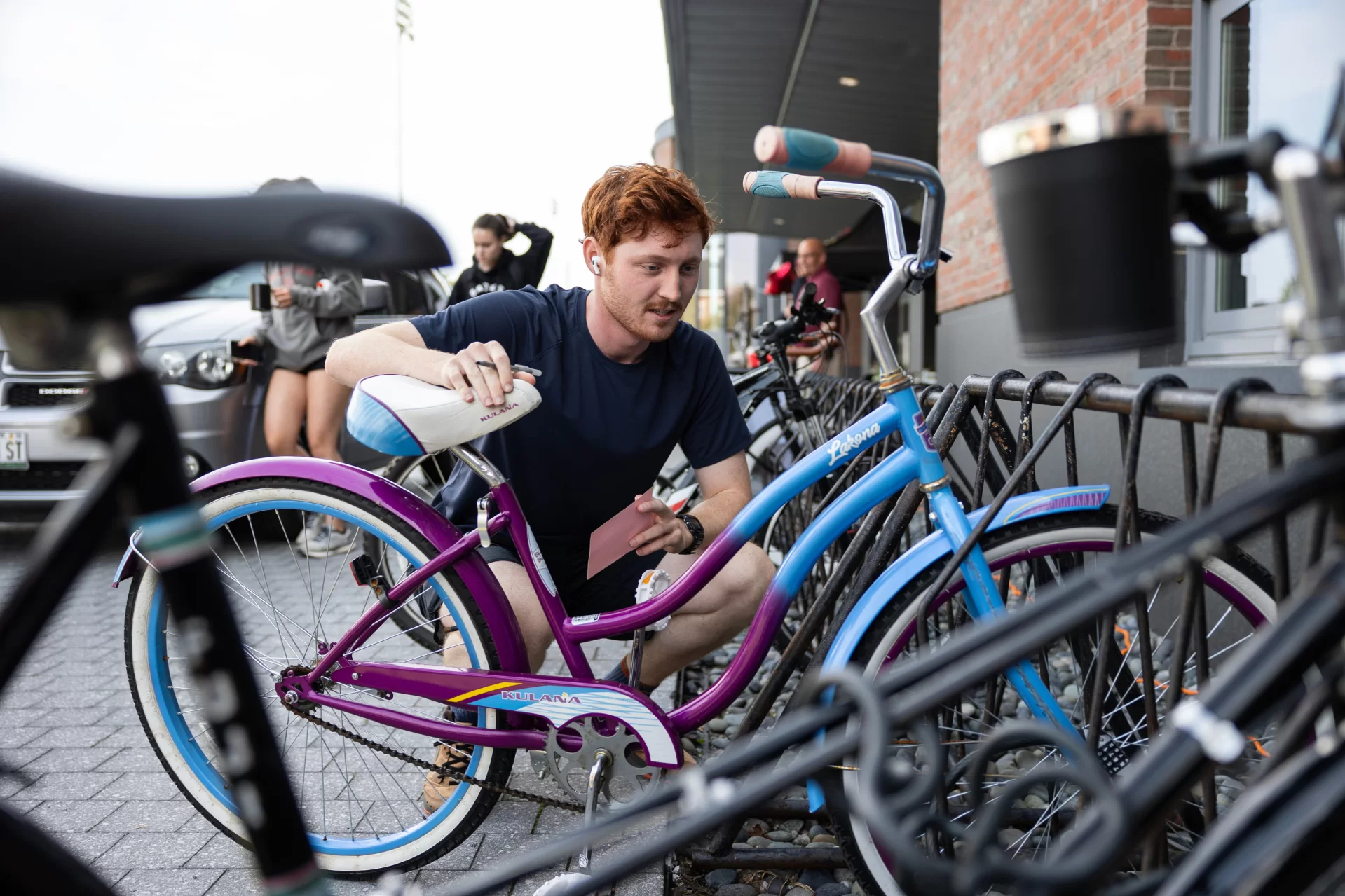 Mac Gaither ‘24 of Palo Alto, Calif., environmental studies, searches for a serial number on his bike outside Commons on during an Annual Bicycle Registration Event hosted by Campus Safety and Rainbow Bicycle on September 25, 2023. 

(Theophil Syslo | Bates College)